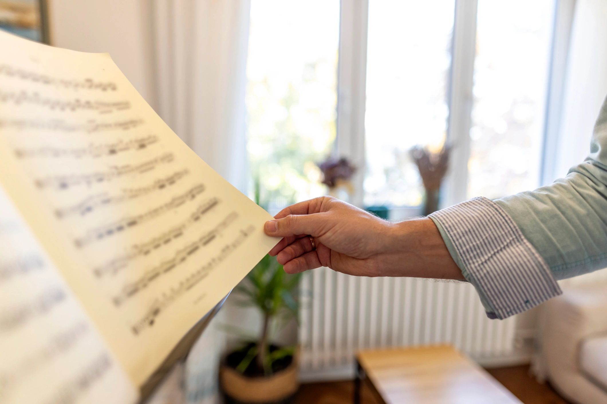 Musician holding sheet music in a bright room