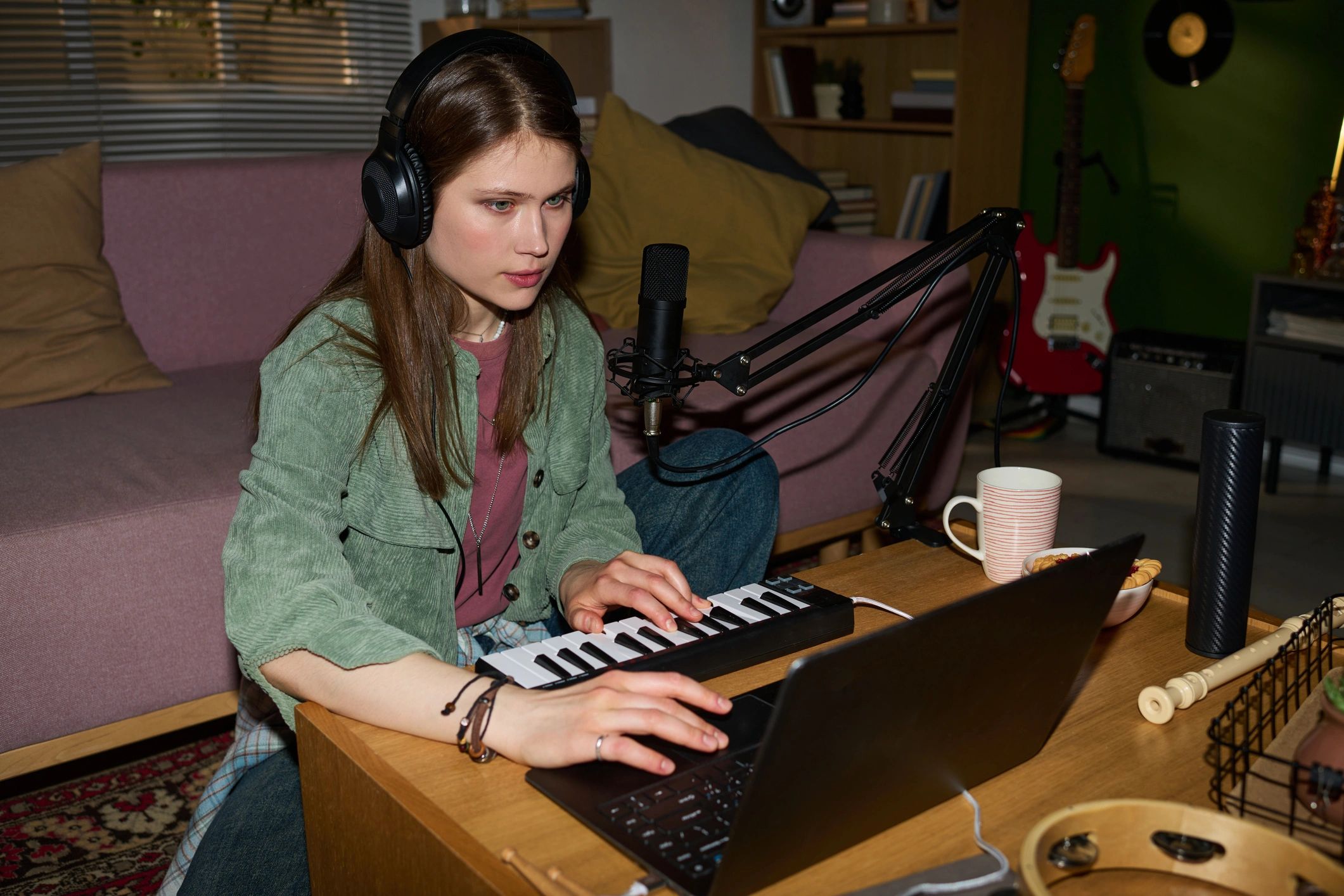 Musician working with keyboard and music tools at a desk